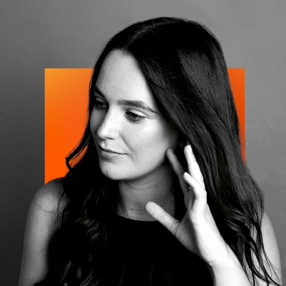 A monochrome portrait of Katy Powell, a young white woman, with orange and grey squares in the background.